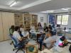 Foto de grupo de pessoas reunidas em volta de uma mesa.